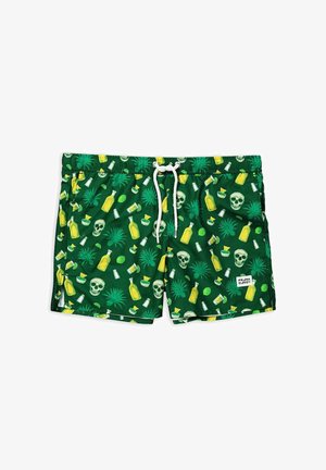 Groene zwembroek met een patroon van gele flessen, schedels, limoenen en tropische planten, met een witte trekkoord en zijzakken.