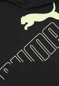 Černá mikina s kapucí se výrazným žlutozeleným logem Puma a designem skákajícího pantera. Měkká textura s detailem přední kapsy.