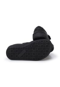 Zwarte schoenen met een gestructureerde rubberen zool met geometrische patronen, klittenbandsluiting en een gevoerd bovenwerk voor comfort.