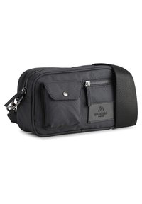 Black fabric shoulder bag with a zip closure, front pocket with snap button, and adjustable strap. Features a brand logo patch.