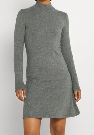 Robe grise en maille à manches longues avec col montant, haut ajusté et jupe légèrement évasée, portée par une personne sur fond blanc.