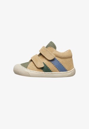 Beige Wildleder Sneaker mit grünen und blauen Zickzackstreifen, ausgestattet mit zwei Klettverschlüssen und einer strukturierten weißen Gummisohle.