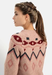 Strickpullover in Hellrosa mit geometrischen Mustern in Rot und Marineblau, runder Halsausschnitt, strukturierter Stoff und lockere Passform.