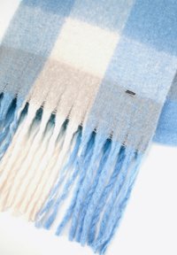 Dziany szalik w kratę o delikatnych odcieniach niebieskiego, beżu i bieli, z postrzępionymi brzegami i małą metalową metką z logo marki.