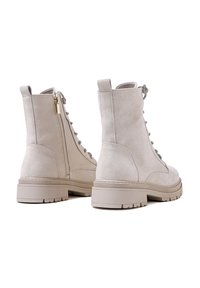 Stivali ankle in suede grigio chiaro con una finitura testurizzata, dotati di una cerniera laterale, stringhe sul davanti e una suola in gomma spessa.