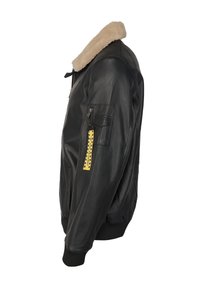 Giacca bomber in pelle nera con colletto in pelliccia beige, tasche con zip laterali, tasca sul petto e un'etichetta di colore giallo attaccata al manica.