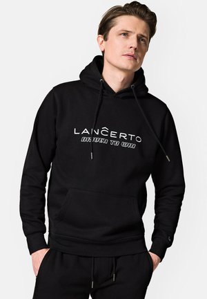Czarna bluza z kapturem z miękkiego materiału, z przednią kieszenią, sznurkiem ściągającym i białym napisem "LANČERTO DRIVEN TO WIN" na klatce piersiowej.
