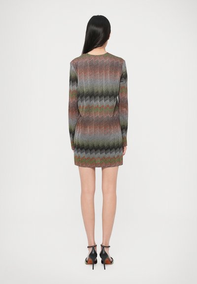 Šaty s dlhým rukávom so vzorom cikcak v tónoch sivej, čiernej, oranžovej a zelenej. Priliehavý strih, dĺžka nad kolená, rebrovaná textúra látky.
