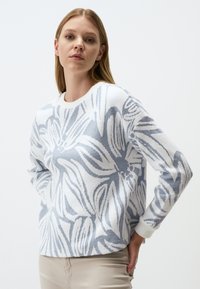 Maglione in morbido tessuto bianco con un motivo floreale blu, scollatura a girocollo e polsini e orlo a costine. Vestibilità semplice e rilassata.