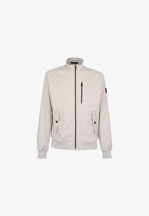 Licht beige jas met rits en opstaande kraag, twee klepzakken met knoop, één verticale borstzak met rits, en geribde manchetten en zoom.