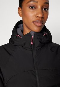 Black hooded jacket with a zipper and pink accents. Features a smooth, slightly puffy texture and a gray inner lining.