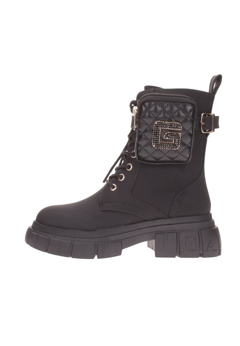 Stivaletto nero con suola piatta spessa, lacci anteriori e tasca trapuntata con dettagli del logo. Realizzato in materiale sintetico testurizzato.