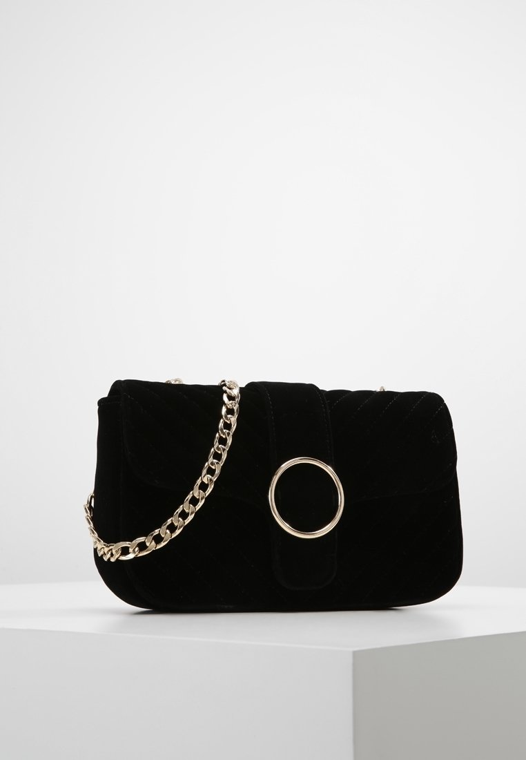 Svart sammetshandväska med kviltad textur, guldkedjesnodd, cirkulär ringdetalj och klaffstängning. Kompakt rektangulär form.