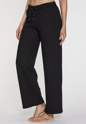 Schwarze Sweatpants mit weitem Bein aus weichem Stoff, ausgestattet mit einem Bund mit Kordelzug und seitlichen Taschen. Sie haben eine lockere Passform und säumige Bündchen.