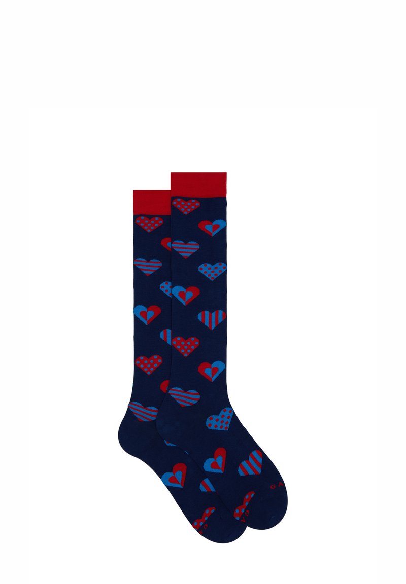 Knee-high socks in navy blue with red and blue heart patterns, featuring polka dots and stripes. Finished with a red cuff.