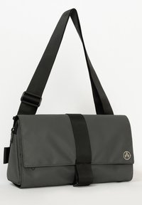 Borsa a tracolla grigia con finitura lucida, cinturino nero regolabile, chiusura a patta e un logo circolare in rilievo sul lato.