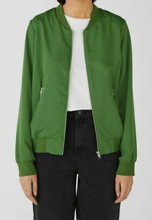 Chaqueta bomber verde hecha de tela suave con cremallera frontal, cuello y puños acanalados, bolsillos laterales y un ajuste holgado.
