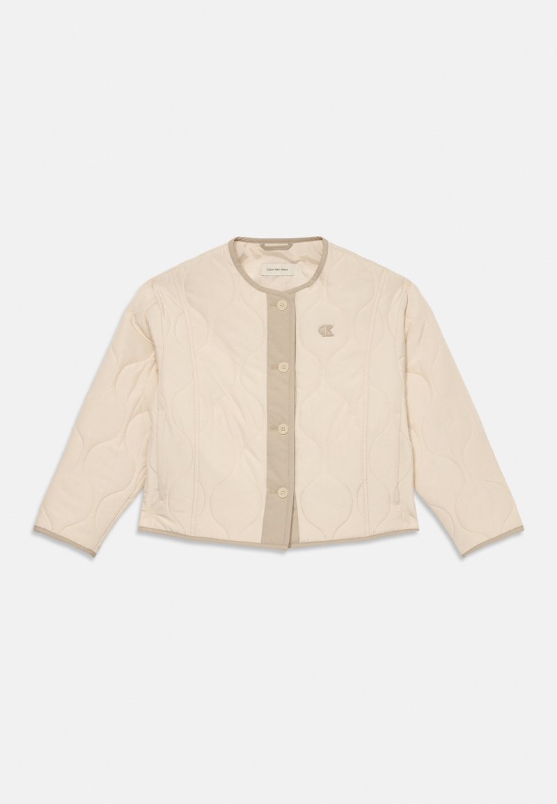 Beige, kviltet jakke med knapper, rund hals, lange ermer og liten "CK"-logo på venstre bryst.