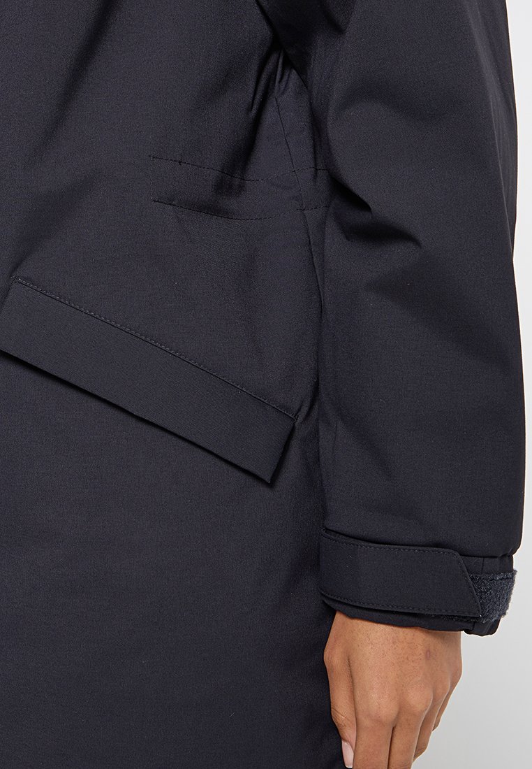 Navyblaue, wasserdichte Jacke mit schlankem Design, ausgestattet mit einer Tasche, elastischen Bündchen und glatter Textur. Geeignet für verschiedene Wetterbedingungen.