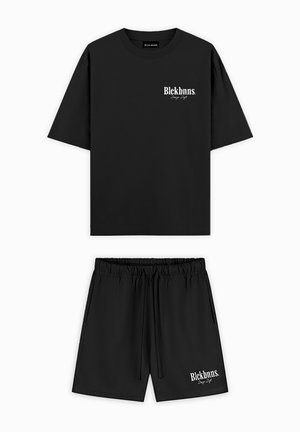 Zwart T-shirt met korte mouwen en korte broek set van lichtgewicht stof, voorzien van een wit logo op de linkerkant van de borst en op de voorkant van de korte broek.