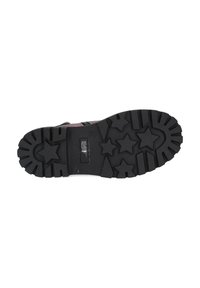 Suela de zapato de goma negra con patrones de estrellas y surcos profundos, que presenta una zona central lisa y bordes con estrías pronunciadas.
