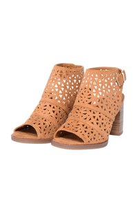Decoltè in suede marrone con punta scoperta, fori a forma triangolare, una fascia larga sopra il piede e un tacco a blocco texturizzato.