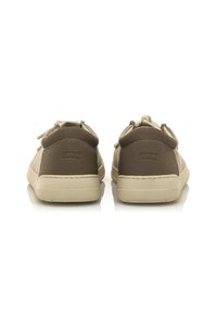 Zapatillas marrones con un upper de textil suave y suela de goma, con acentos y cordones en beige a contraste, vistas desde la parte trasera.