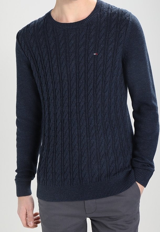 Pull en maille bleu marine avec un motif torsadé, col rond, poignets et ourlet côtelés. Petit logo sur la poitrine.