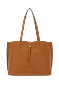 Sac fourre-tout en cuir tan avec deux poignées de shoulder, détails en laiton doré, surface texturée et design minimaliste. Présente un logo en bas.