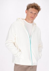 Witte hoodie met een turkooise rits, met een gladde textuur, lange mouwen en voorzakken. Draag je over een lichte top.
