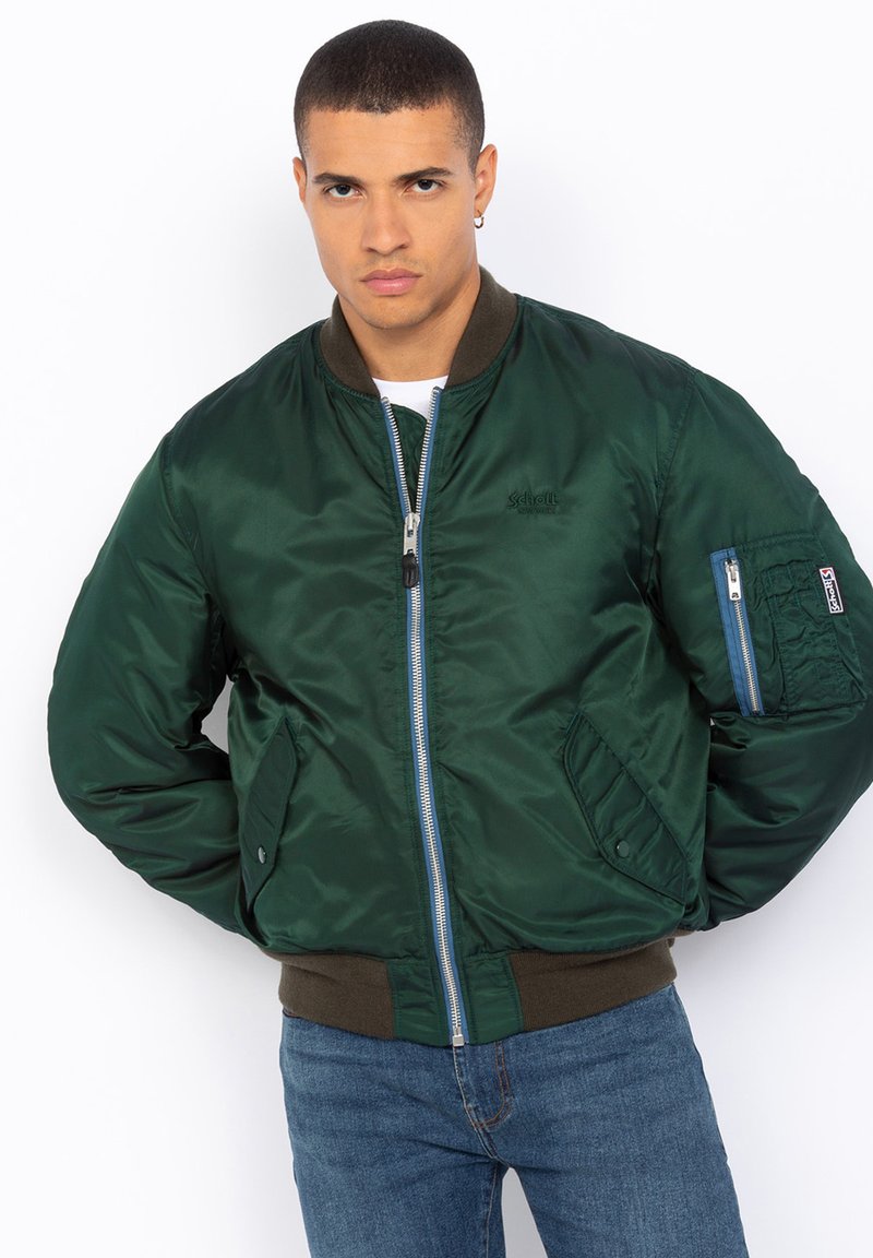 Giacca bomber verde con finitura satinata, zip frontale, polsini e orlo a costine, e tasca con patta sul braccio sinistro.