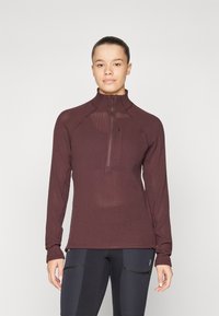 Burgundy hosszú ujjú cipzáras felső, texturált, lélegző anyagból készült, álló gallérral. Fitted fazon és kontrasztos varrási részletek jellemzik.