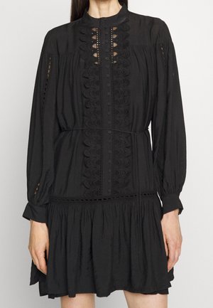 Robe noire à manches longues, avec des détails en dentelle, un devant à boutons et une jupe évasée. Fabriquée à partir d'un tissu léger avec une finition texturée.