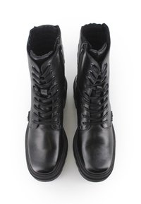 Botas de cuero negro con un tobillo alto, cordones en la parte frontal y cremallera lateral. Textura suave con una suela robusta y cuello acolchado para mayor comodidad.