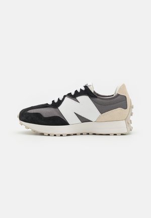 Scarpe da ginnastica nere e grigie con logo bianco, realizzate in pelle scamosciata e mesh, con suola strutturata e dettagli beige sul tallone.
