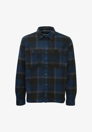 Chemise à carreaux bleus en tissu doux. Présente un bouton-avant, deux poches poitrine et un col. Texturée avec un motif à carreaux.
