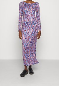 Sukienka z długim rękawem, dopasowana, wykonana z elastycznego materiału w żywej, abstrakcyjnej wzorze w odcieniach różu, niebieskiego i fioletowego. Połączona z czarnymi zklatami.