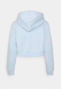 Korsad hoodie i ljusblått tyg. Har en dragsko i huvan, ribbstickade ärmslut och nederkant, med en mjuk och slät textur utan synliga mönster.