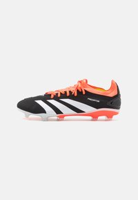 Scarpa da calcio nera con accenti arancioni, strisce bianche e una parte superiore testurizzata. Progettata per la trazione con una suola dai colori vivaci.