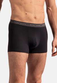 Svarta boxershorts i mjukt tyg, med ett bekvämt elastiskt midjeband som har "OLAF BENZ"-logotypen i grått.