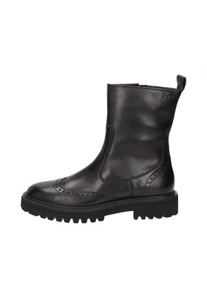 Bottine en cuir noir avec un bout rond, détails de brogue décoratifs et une semelle épaisse. Dotée d'une languette à l'arrière pour un enfilage facile.