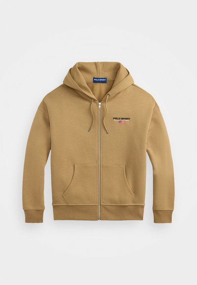 Sweatshirt com fecho na frente, de cor bege, com um bolso frontal, capuz ajustável e o logótipo "POLO SPORT" bordado em vermelho e azul no lado esquerdo do peito. Material em mistura de algodão.