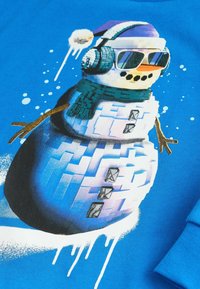 Felpa grafica blu con un pupazzo di neve che indossa cuffie, occhiali da sole e un cappello viola. Dettagli notevoli includono una sciarpa verde e braccia a forma di bastone.