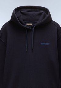 Sudadera azul marino con un bolsillo frontal, cordones y un parche de logo en azul. Fabricada con un suave material de algodón texturizado.
