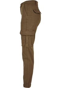 Brown cargo pants with side flap pockets, front slash pocket, and elasticized cuffs viewed from the side.