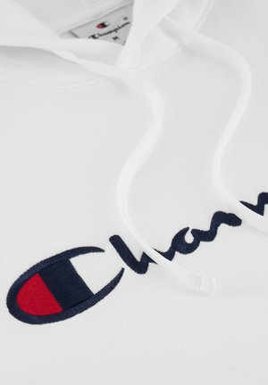 Haut à capuche blanc avec un logo "Champion" brodé navy et un accent rouge. Comprend des cordons blancs et une texture en coton lisse.
