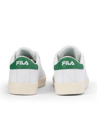 Sneakers bianchi con accenti verdi sul tallone e logo Fila. Realizzati in materiale liscio con suola in gomma e design semplice.
