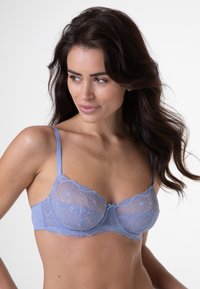 Reggiseno in pizzo blu chiaro con motivo floreale. Trasparenza nei coppe in pizzo, stecca imbottita e spalline regolabili. Tessuto morbido e dettagli delicati.