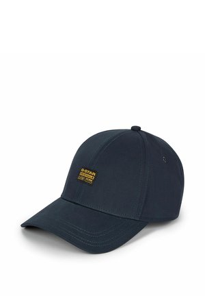 Casquette de baseball bleu marine foncé avec une visière incurvée et un petit écusson logo G-Star Originals jaune et noir sur le panneau avant.