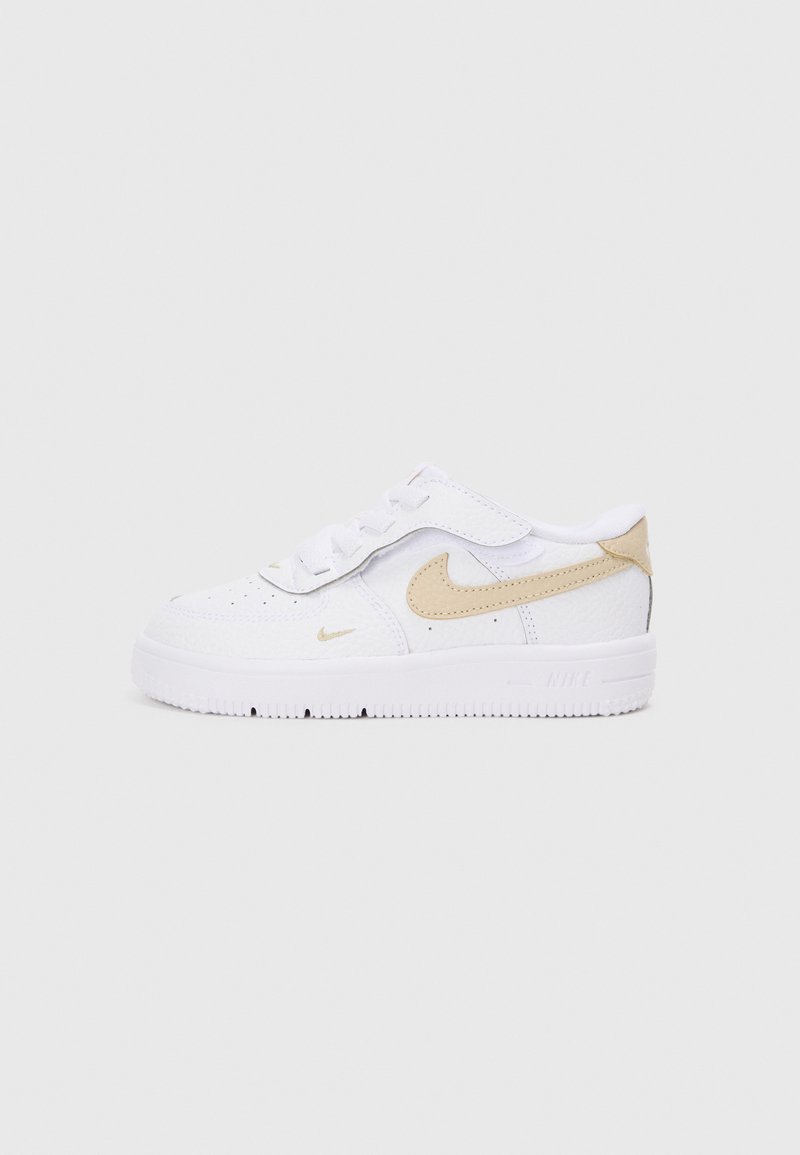 Bele čevlje Nike, ki imajo teksturirano usnje, svetlo bež ševron in gumijast podplat z vzorcem. Zavezovanje z vezalkami ter dodatna zadrga z ježkom.